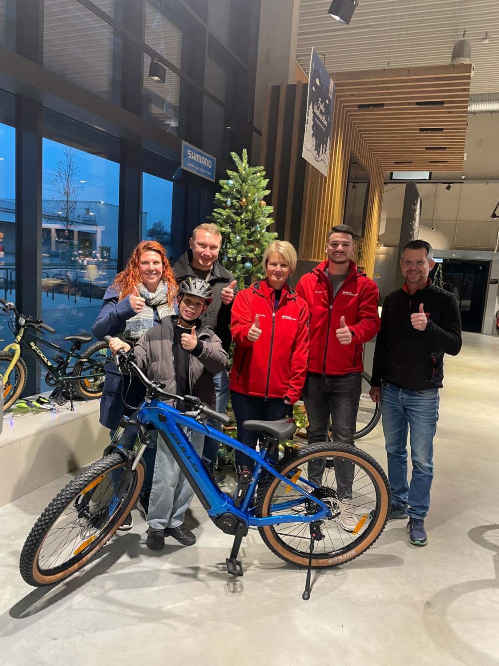 Collin, seine Eltern, Vertreter von Marcels Wunschmomente und der Chef von Zweirad Carle mit dem neuen E-Bike