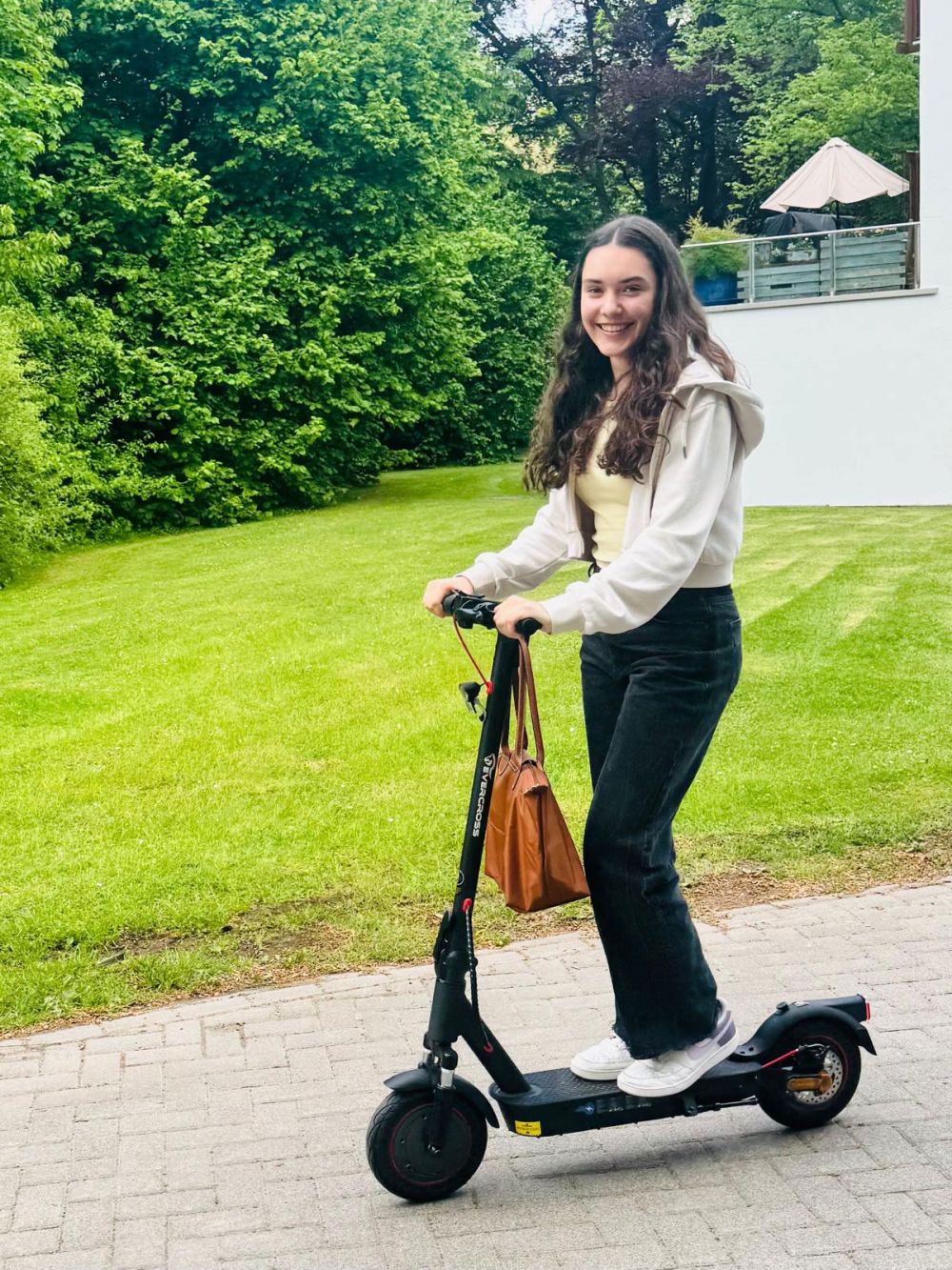 Henris Schwester mit Roller und Handtasche